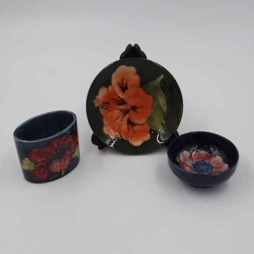 248 - Trio of Moorcroft items to include a small footed bowl in the Anemone pattern, a Hibiscus pin dish a... 