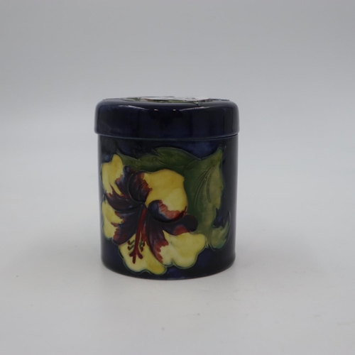 288 - Moorcroft lidded pot in the Hibiscus pattern on a cobalt blue ground, original paper label to base, ... 