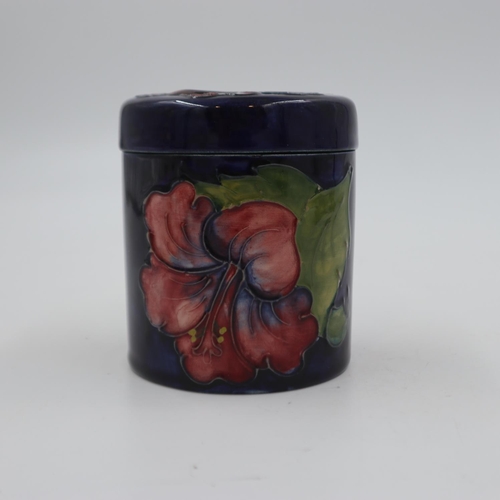 288 - Moorcroft lidded pot in the Hibiscus pattern on a cobalt blue ground, original paper label to base, ... 