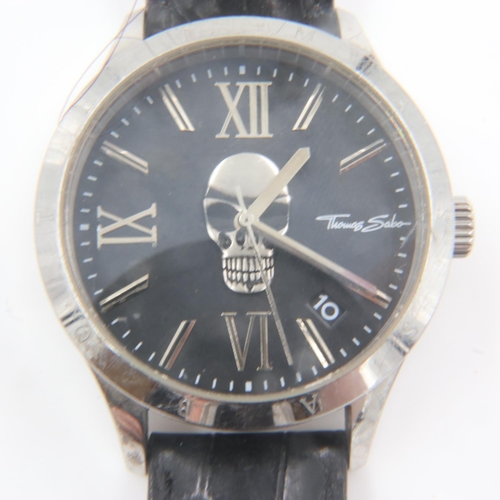 78 - THOMAS SABO: gents steel cased quartz wristwatch, skull design dial with date aperture on a black le... 