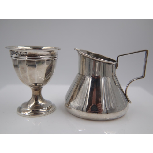 133 - Hallmarked silver cream jug in the manner of Christopher Dresser, with a hallmarked silver eggcup, c... 