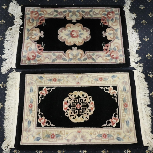 2097 - Pair of 20th century Chinese thick pile rugs with floral design against a black ground, each 100 x 6... 