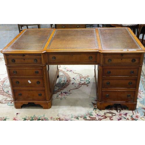 2140 - A reproduction yew twin pedestal partners desk, with inverted-break front to each side, three panels... 