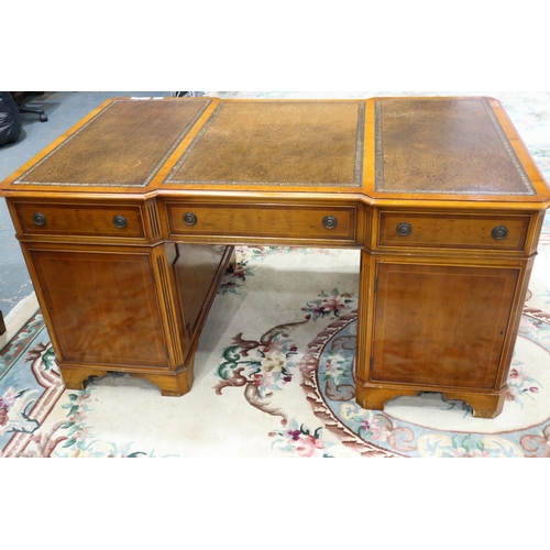 2140 - A reproduction yew twin pedestal partners desk, with inverted-break front to each side, three panels... 