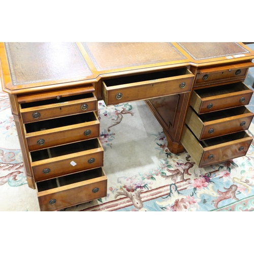 2140 - A reproduction yew twin pedestal partners desk, with inverted-break front to each side, three panels... 