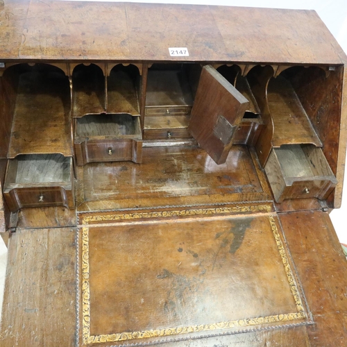 2147 - *KEYS IN OFFICE* An early 18th century walnut bureau, with stepped fitted interior, two short above ... 