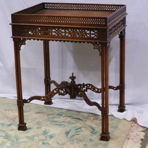 2204 - A reproduction walnut table, having pierced gallery and frieze, raised on tri-columnar supports and ... 