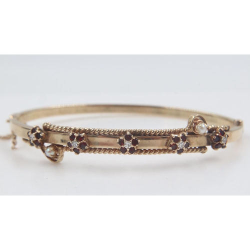 112 - Gold bangle decorated with rubies, diamonds and seed pearls, 12.6g. UK P&P Group 1 (£16+VAT for the ... 