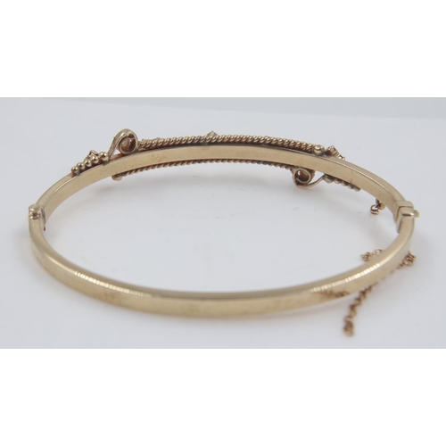 112 - Gold bangle decorated with rubies, diamonds and seed pearls, 12.6g. UK P&P Group 1 (£16+VAT for the ... 