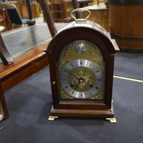 323 - Oak cased brass faced mantel clock raised on brass bracket feet, 26cm in height. Not available for i... 