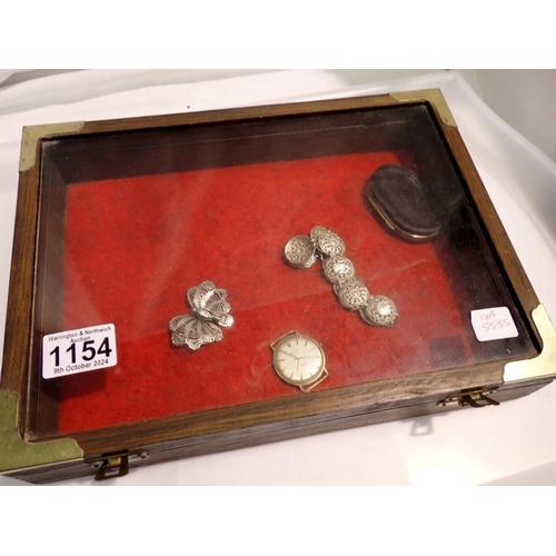 1154 - Glass topped brass bound table top display box, containing a white metal bracelet, Rotary gold plate... 