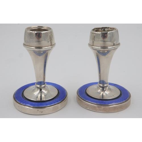 126 - Hallmarked silver pair of candlesticks, each with guilloche enamelled border to bases, one having da... 