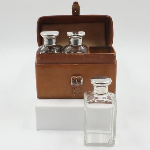 73 - Leather cased set of three cut glass bottles with hallmarked silver screw-tops. Bottle size: H: 12 c... 