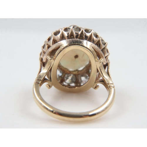 13 - 18ct gold cocktail ring, set with a large cabochon opal, surrounded by twelve old-cut diamonds total... 