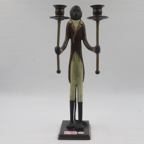 262 - Unusual figural candle stick in the form of an anthropomorphic monkey holding two torches, H: 44 cm.... 