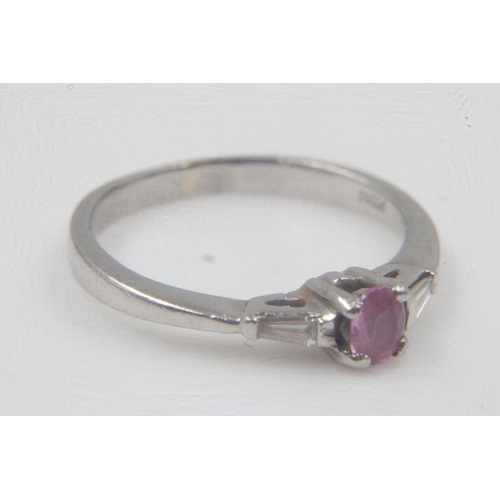 15 - 950 platinum solitaire ring, set with an oval pink sapphire, flanked by two tapering baguette diamon... 