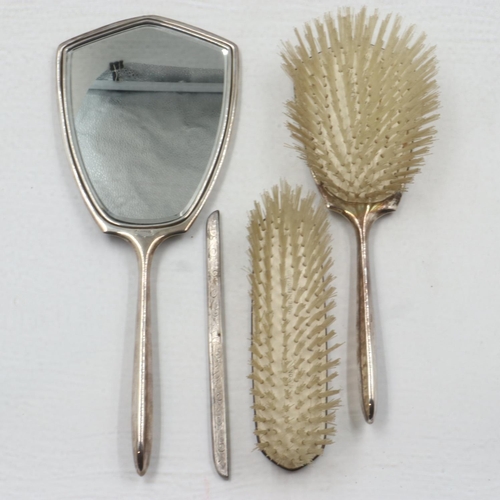 121 - Hallmarked silver dressing set comprising two brushes and mirror, with silver mount for comb (lackin... 