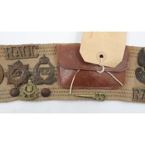 2270 - Collection of WWII cap, collar and shoulder badges with uniform buttons affixed to a leather and can... 