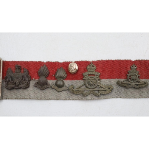 2326 - Collection of WWII and later regimental cap and collar badges affixed to a stable belt, mostly Royal... 