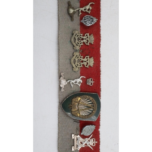 2326 - Collection of WWII and later regimental cap and collar badges affixed to a stable belt, mostly Royal... 