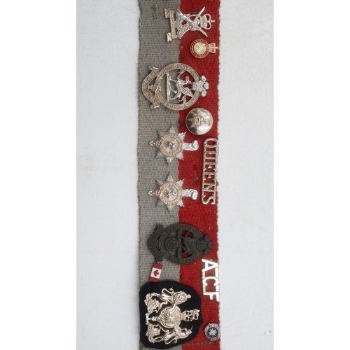 2326 - Collection of WWII and later regimental cap and collar badges affixed to a stable belt, mostly Royal... 