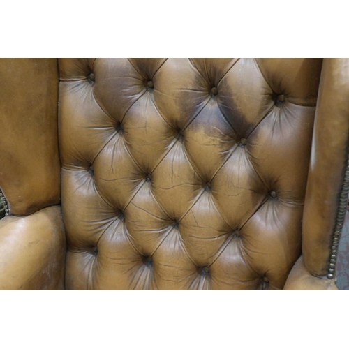 2033 - Early 20th century distressed tan leather Chesterfield wingback fireside armchair. Not available for... 