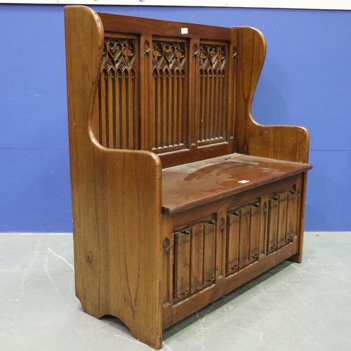 2028 - A 20th century carved oak monk's bench or settle in the 17th century gothic style, with hinged box-s... 