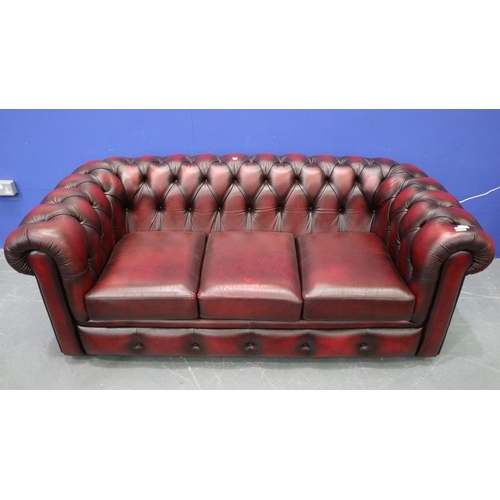 2042 - A modern Chesterfield three-seat sofa in ox-blood red leather. Not available for in-house P&P