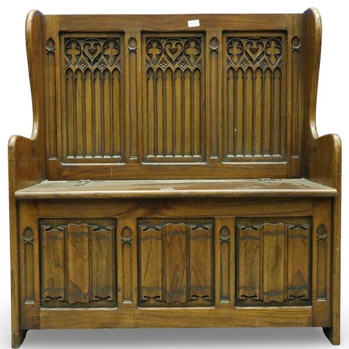 2028 - A 20th century carved oak monk's bench or settle in the 17th century gothic style, with hinged box-s... 