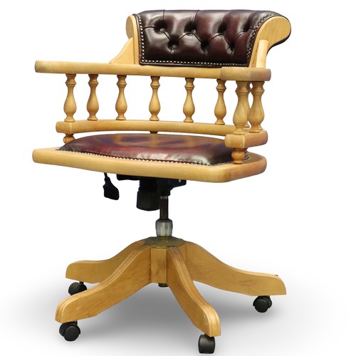 2029 - A modern light elm framed desk chair in the Chesterfield style, revolving and supported on a five-sp... 