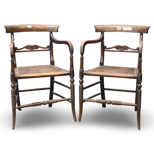 2048 - A pair of Regency period rosewood elbow chairs, each having bergère seats, with turned supports and ... 