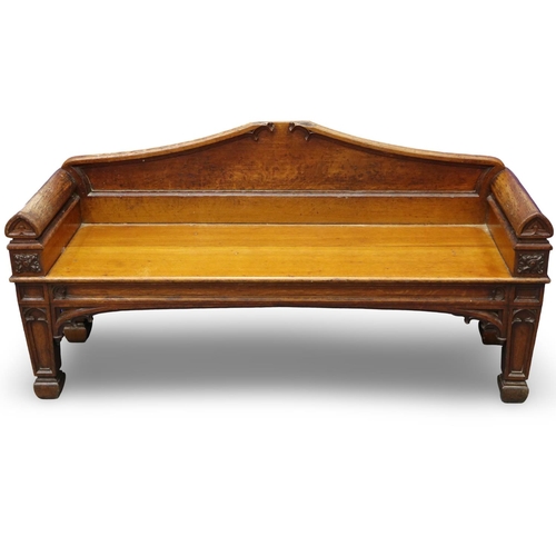 2044 - An early 19th century carved oak settle or window seat, decorated in the Gothic manner, with straw-f... 