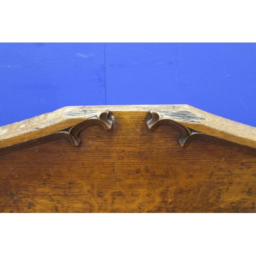 2044 - An early 19th century carved oak settle or window seat, decorated in the Gothic manner, with straw-f... 