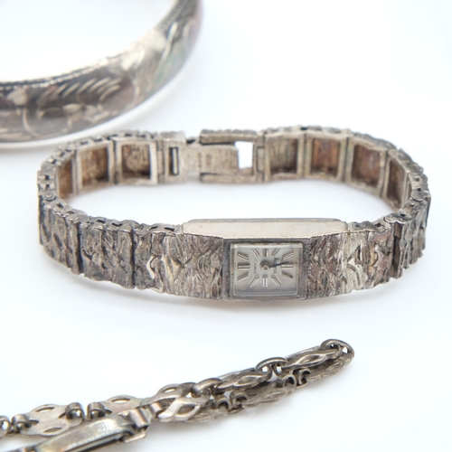 113 - Two silver bangles, a bracelet and a textured Accurist ladies wristwatch, 73g combined. UK P&P Group... 
