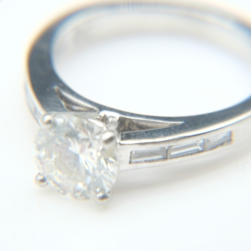 61 - Platinum 1.8ct round brilliant cut diamond set ring with baguette cut diamonds to the shoulders, siz... 