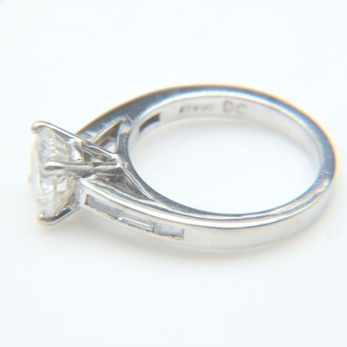 61 - Platinum 1.8ct round brilliant cut diamond set ring with baguette cut diamonds to the shoulders, siz... 