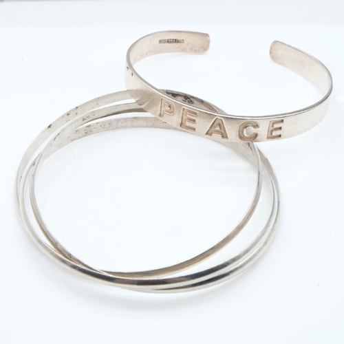 63 - Silver 'Peace' bangle and a triple bangle, 36g combined. UK P&P Group 0 (£7+VAT for the first lot an... 