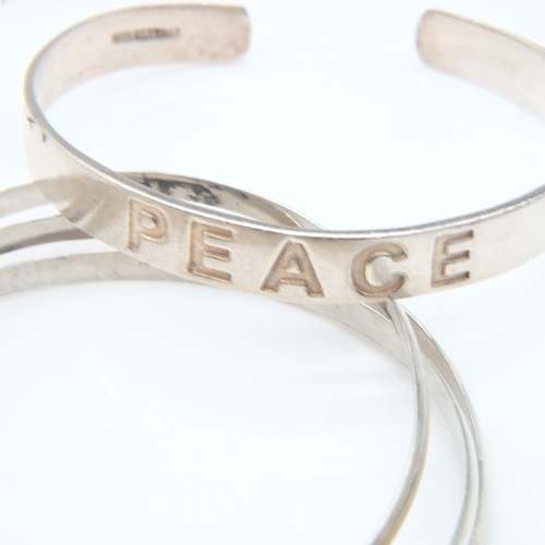 63 - Silver 'Peace' bangle and a triple bangle, 36g combined. UK P&P Group 0 (£7+VAT for the first lot an... 
