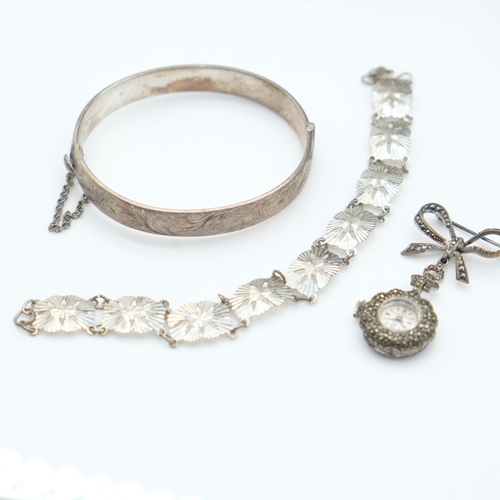 94 - Hallmarked silver bangle with chased decoration and safety chain, a silver panel bracelet and a marc... 