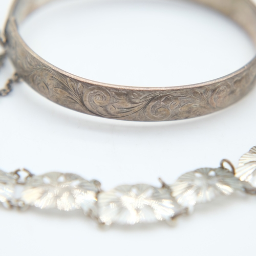 94 - Hallmarked silver bangle with chased decoration and safety chain, a silver panel bracelet and a marc... 