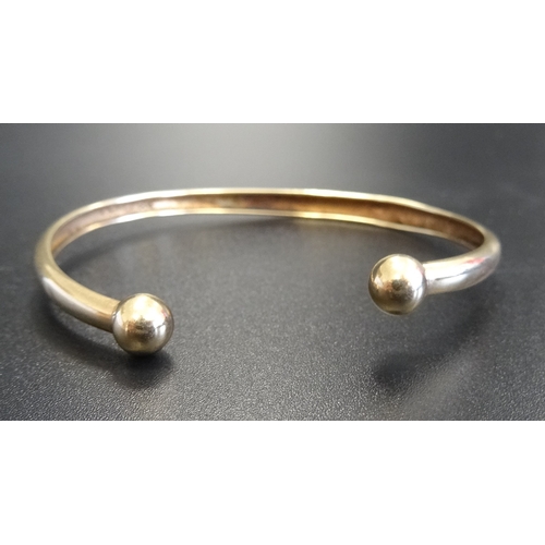 60 - NINE CARAT GOLD BANGLE
with ball finials, approximately 2.5 grams