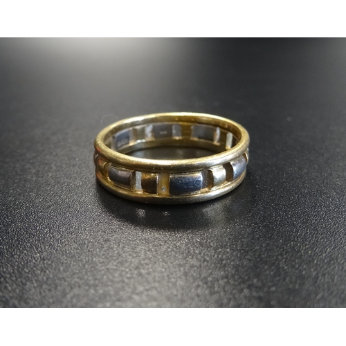 81 - EIGHTEEN CARAT TWO TONE GOLD RING
the band with pierced decoration, ring size Q and approximately 5.... 