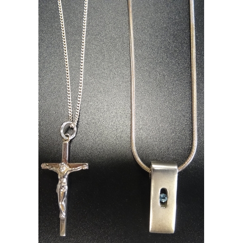 82 - TWO SILVER PENDANTS
comprising a blue topaz set rectangular example and a cross pendant, both on sil... 