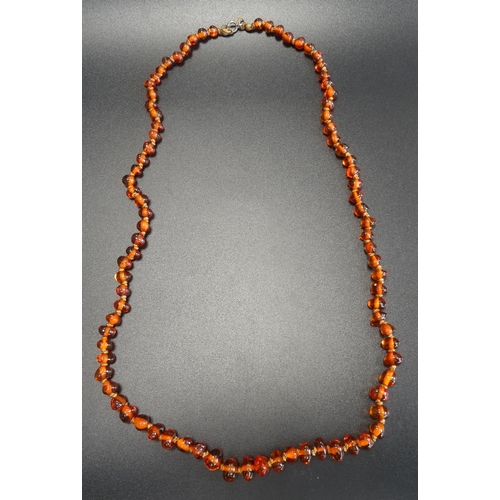 102 - AMBER BEAD NECKLACE
the irregular beads individually knotted, 63.5cm long  -  RETURNED