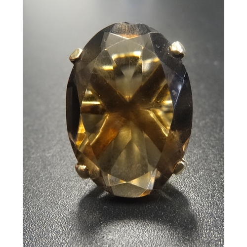 131 - SMOKY TOPAZ SINGLE STONE DRESS RING 
the oval cut topaz on nine carat gold shank with raised setting