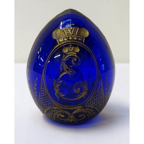 180 - FABERGE CUT BLUE GLASS EGG WITH GILT DECORATION
depicting a vase of flowers to one side and an E mon... 