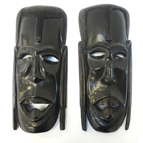 225 - PAIR OF AFRICAN EBONISED TRIBAL MASKS
depicting warriors, with cut out eyes and mouth, each 31cm hig... 