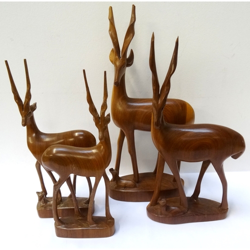 266 - FOUR CARVED AFRICAN HARDWOOD IMPALAS
all on a plinth base, three with a calf to foot (4) - RE-OFFERE... 