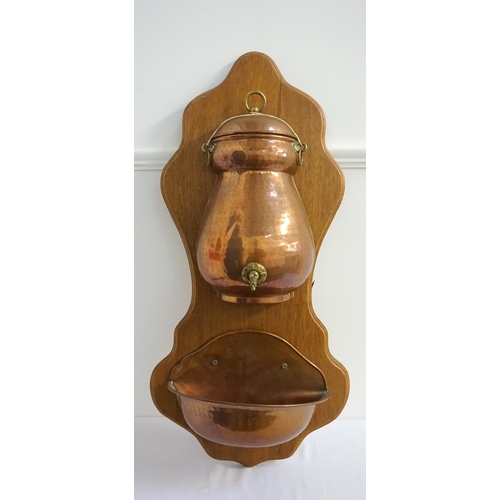 394 - FRENCH WALL MOUNTED WASH STAND
on a shaped mahogany panelled back, with a shaped hammered copper wat... 