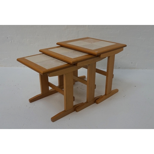 406 - NEST OF THREE OAK TILE-TOP TABLES 
raised on shaped ends with stretchers, the largest 44.8cm wide